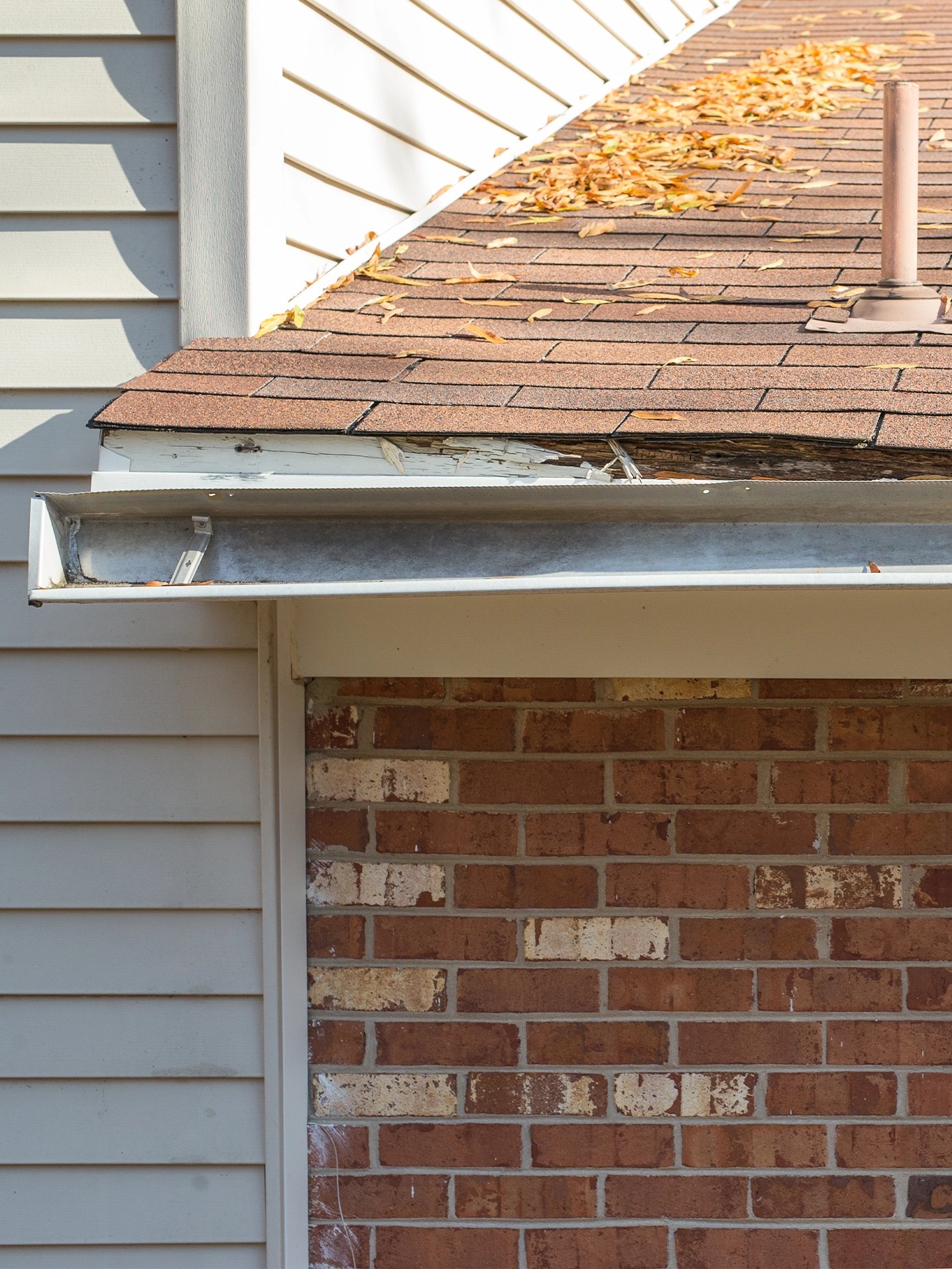 Close-up of residential roof damage caused by moisture, aging materials, and inadequate drainage.