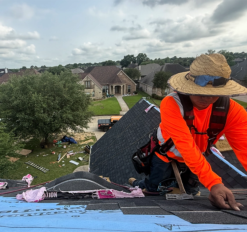 Professional roofer installing new shingles on a residential roof replacement project.