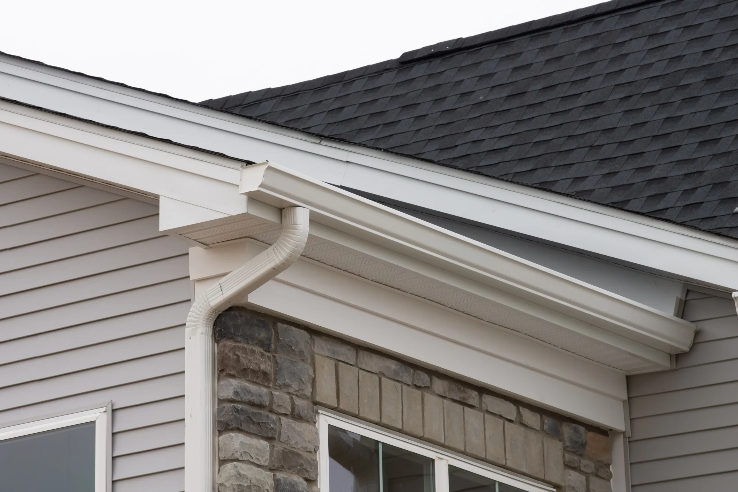 White seamless gutter and downspout system installed to provide reliable drainage and protect the home from water damage.